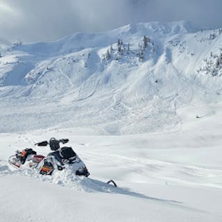 An large avalanche with wide propagation on a fairly short slope. A sled is in the foreground.