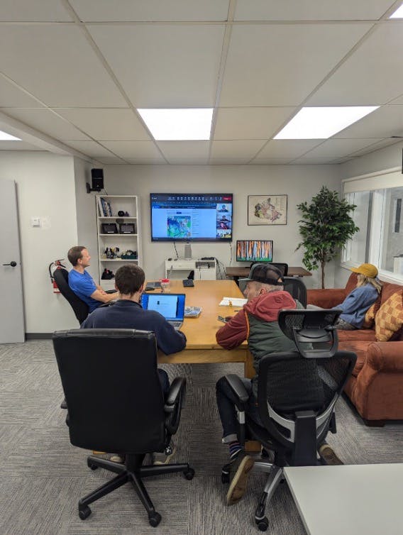 A group of forecasters gather around a table to review conditions data