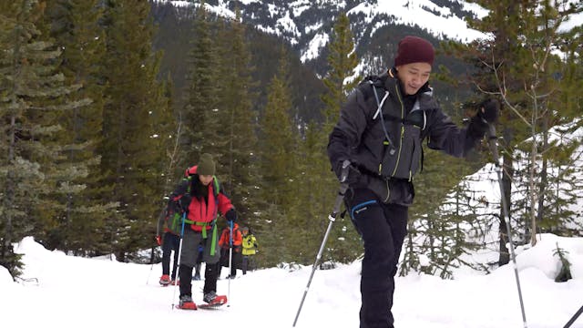 Individuals snowshoeing in the mountains during an AST 1 course
