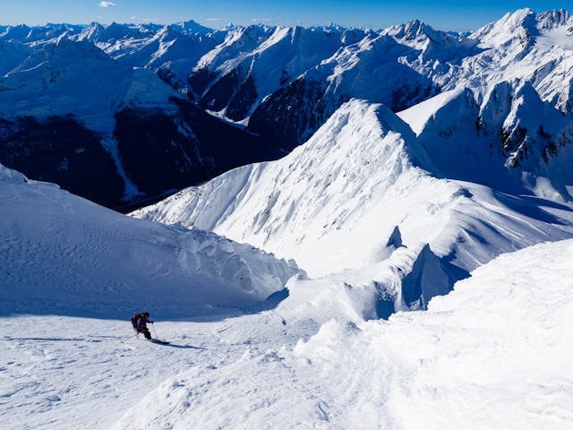 Skier in steep couloir.