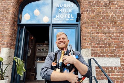 A man holding bottles outside the Burnt Milk Hotel in Liverpool