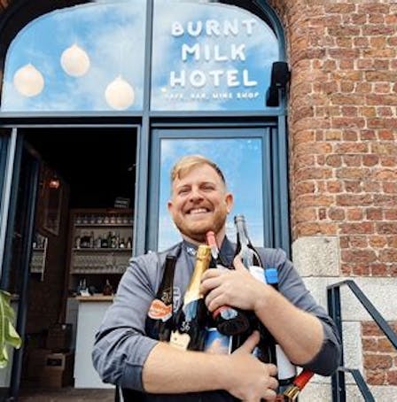 A man holding bottles outside the Burnt Milk Hotel in Liverpool