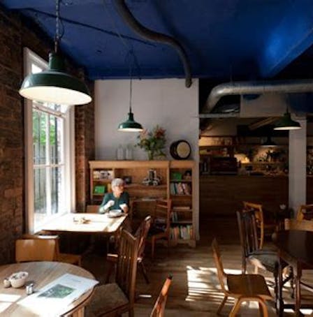 Woman enjoying coffee in The Glad Cafe in Glasgow