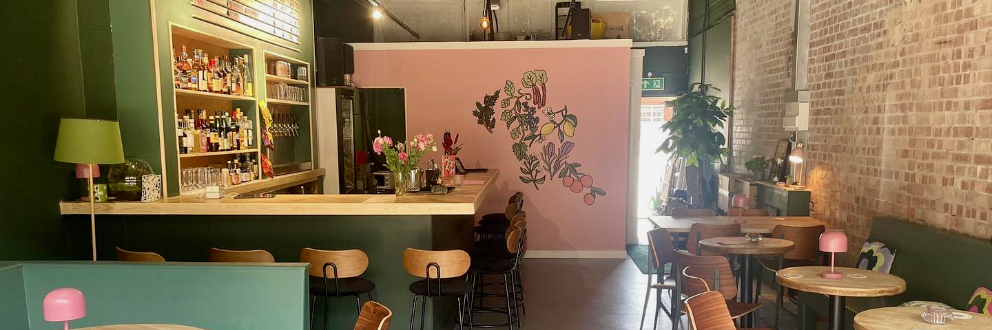 The interior of Pray Tell bar with a floral mural on the wall