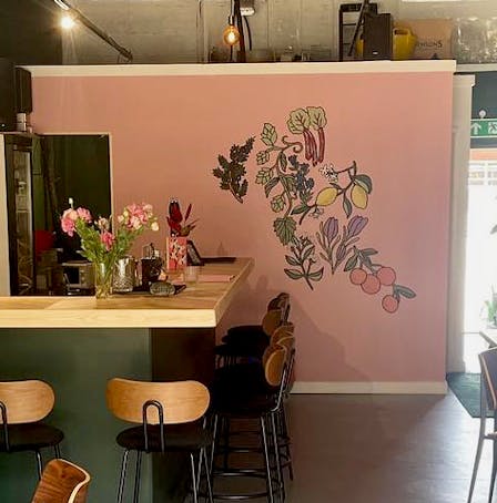 The interior of Pray Tell bar with a floral mural on the wall