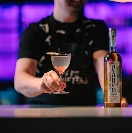 A bartender at Shapeshifters bar serving an Avallen cocktail