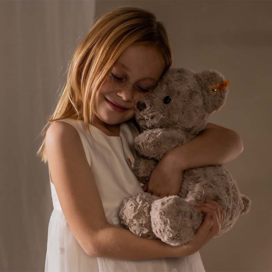 Mädchen kuschelt mit Teddybär