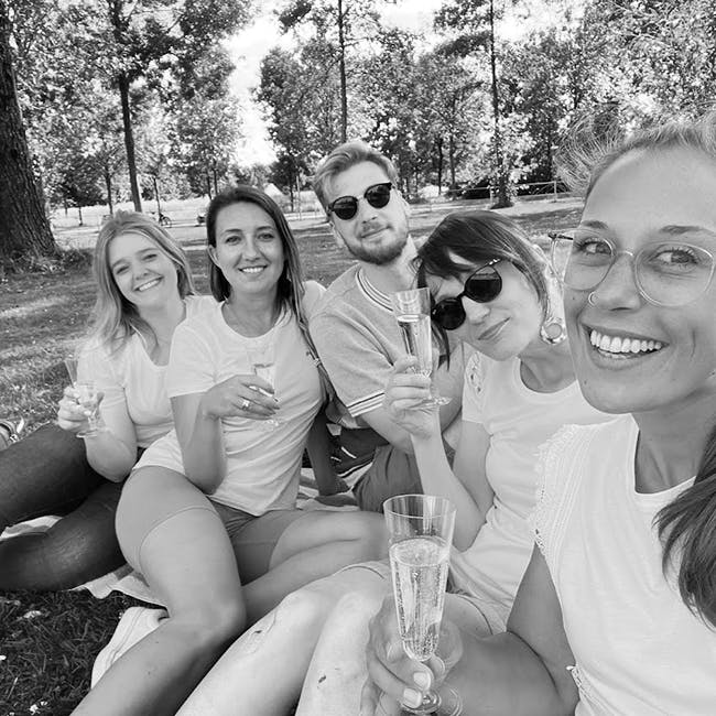 Fünf Teammitglieder Lächeln mit Sektgläsern für ein Selfie auf einem gemeinsamen Ausflug