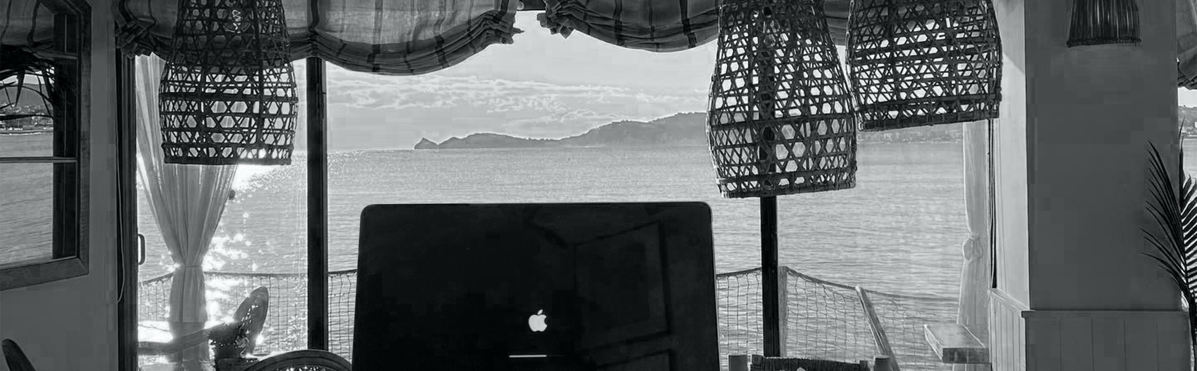 Macbook vor Fenster mit Aussicht auf das Meer