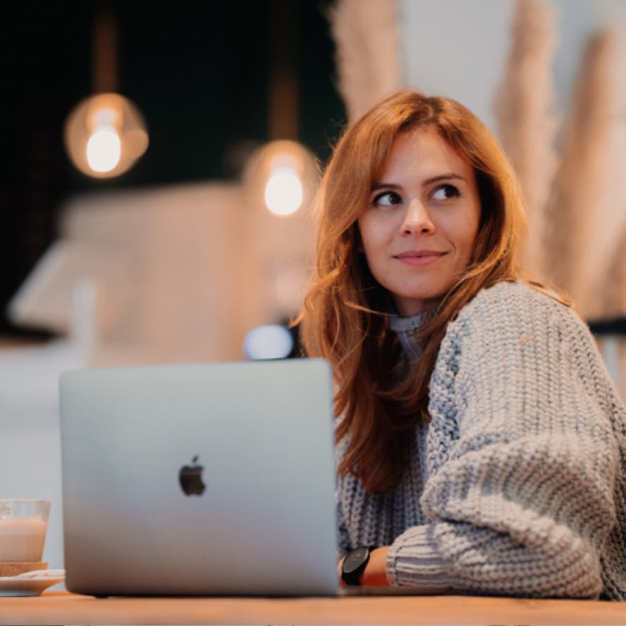 Eine Frau, die vor einem MacBook sitzt. Eine Frau, die vor einem MacBook sitzt.