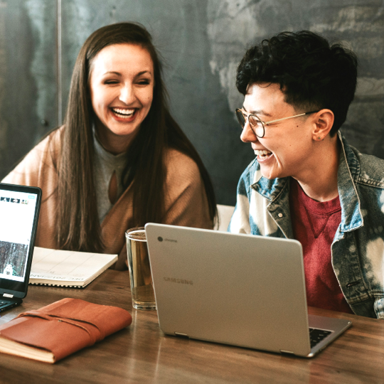 Ein Mann und eine Frau sitzen vor ihren Laptops