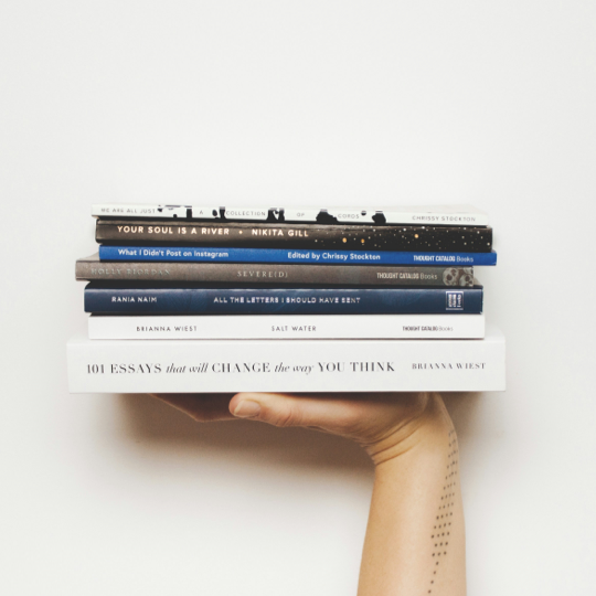 Eine Hand, die mehrere Bücher hält