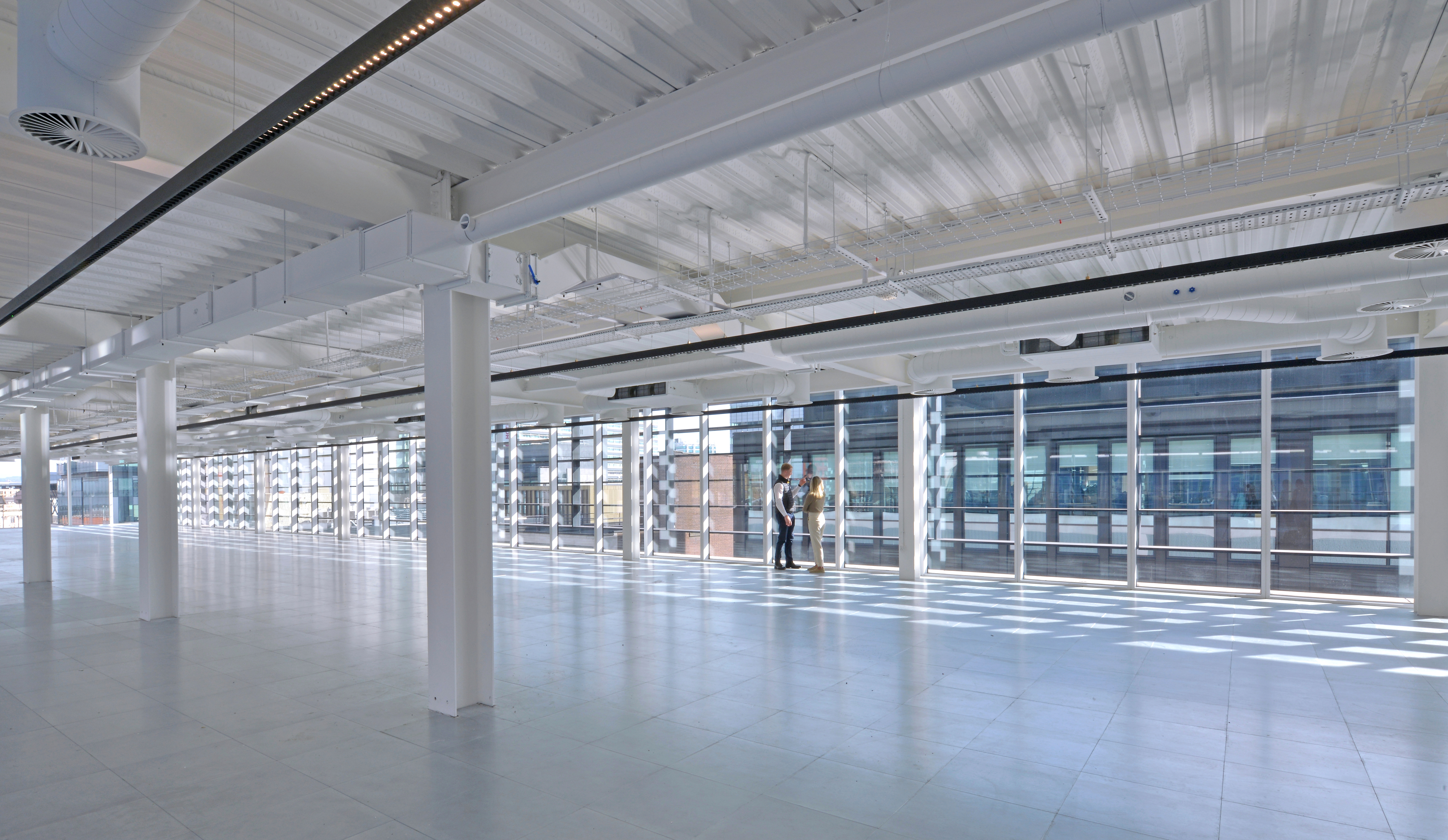 Open office floor at Aviary with exposed services and floor-to-ceiling windows