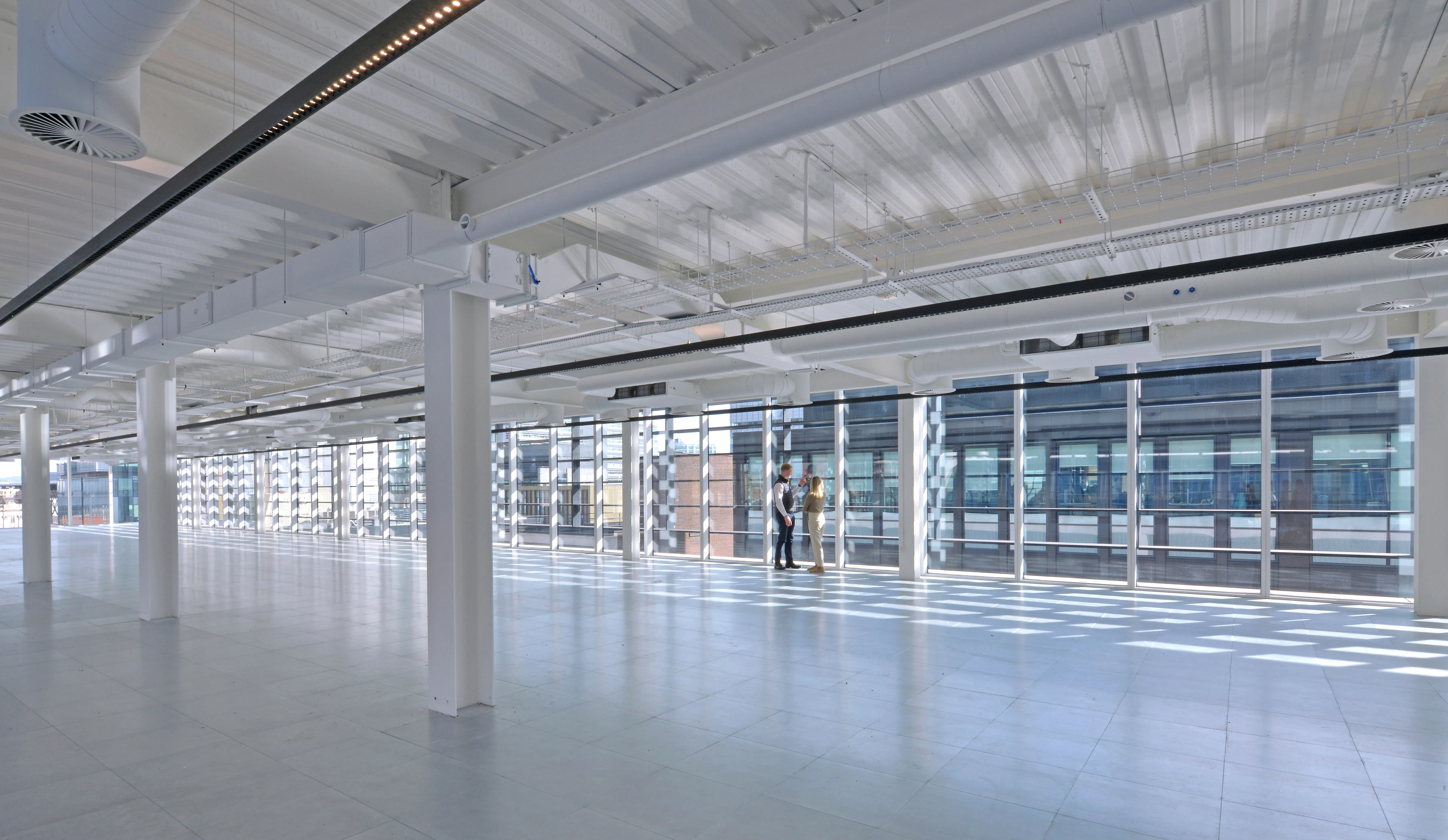 Open office floor at Aviary with exposed services and floor-to-ceiling windows