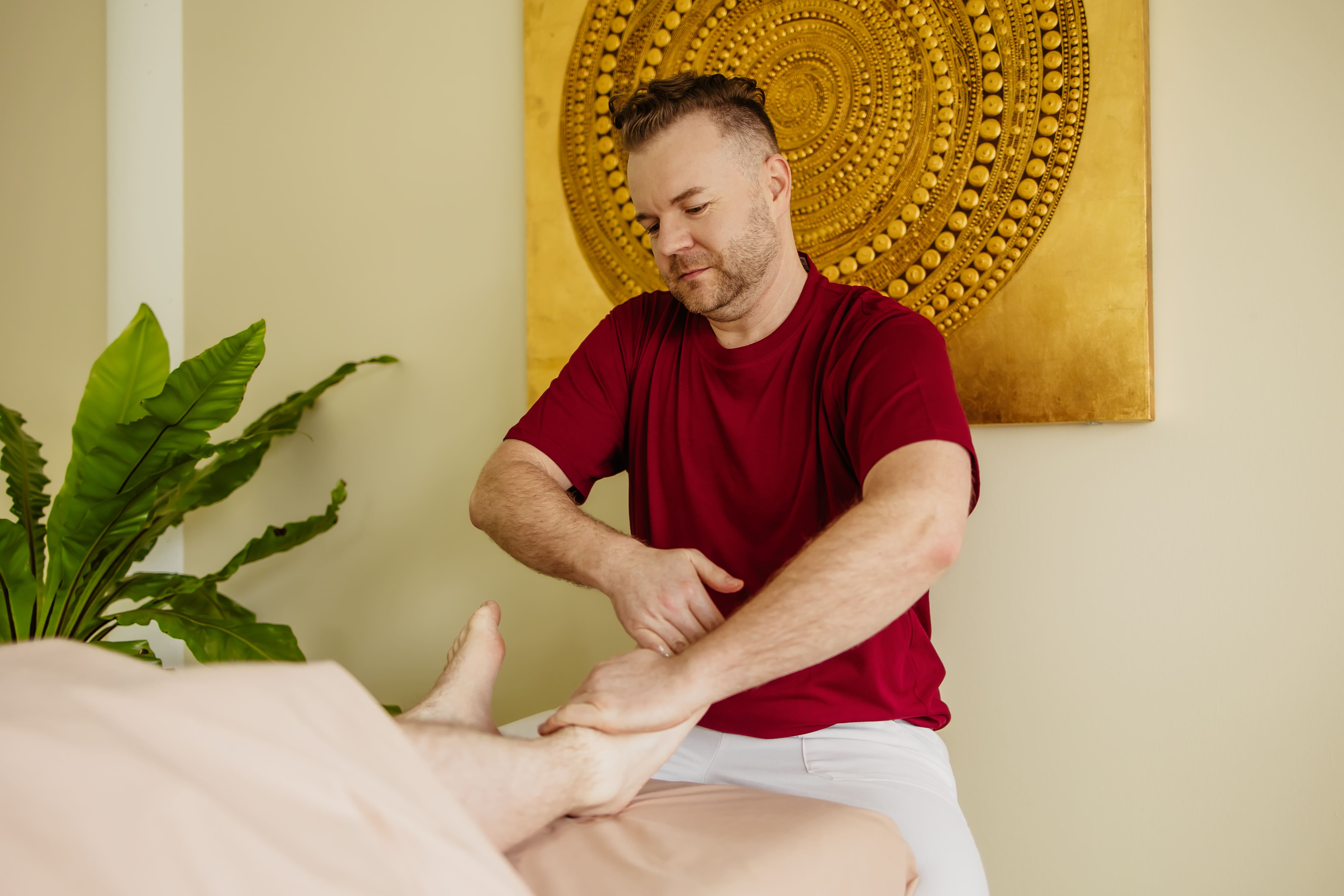Masseur gibt Patientin ayurvedische Fußmassage