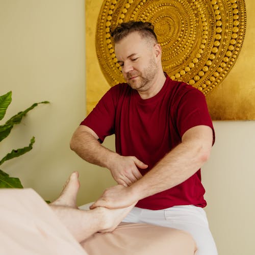 Masseur gibt Patientin ayurvedische Fußmassage
