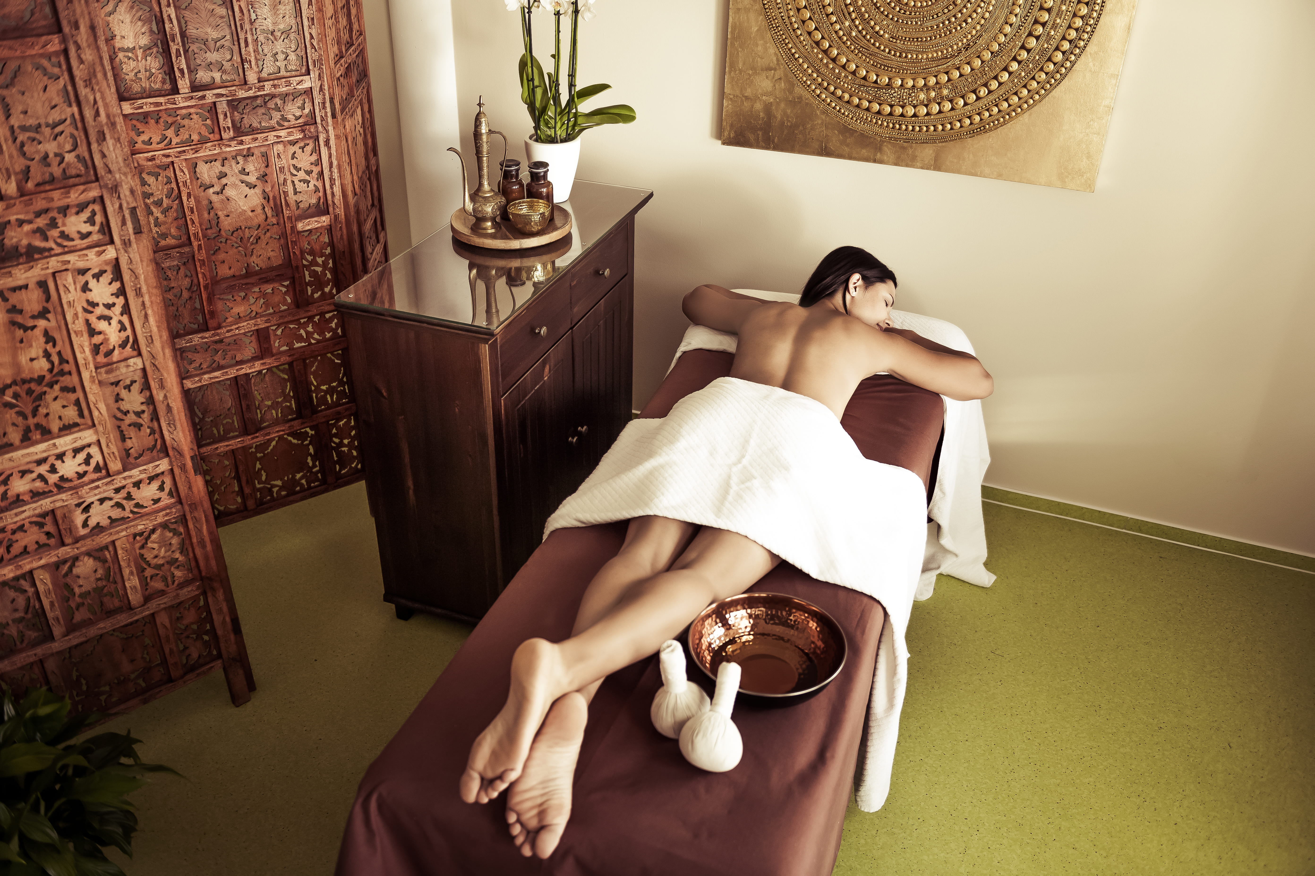 Frau liegt auf einer ayurvedischen Behandlungsliege