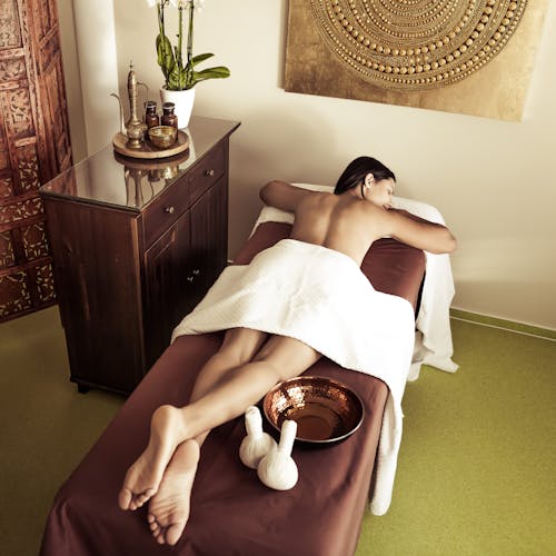 Frau liegt auf einer ayurvedischen Behandlungsliege