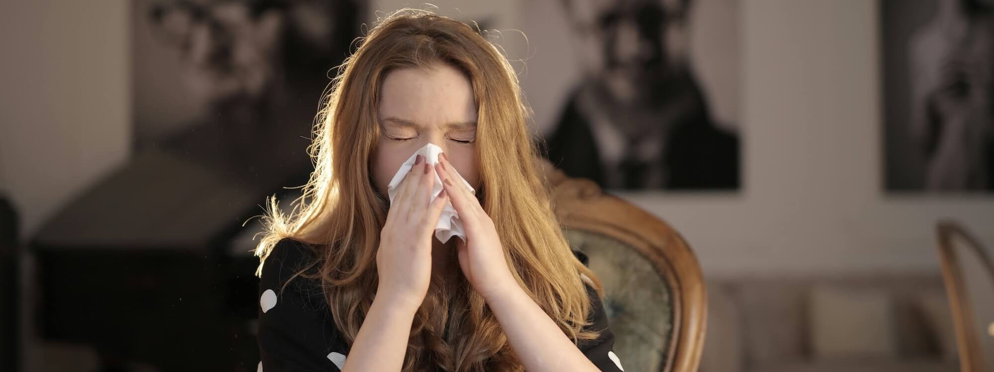 Frau mit Allergie putzt sich die Nase