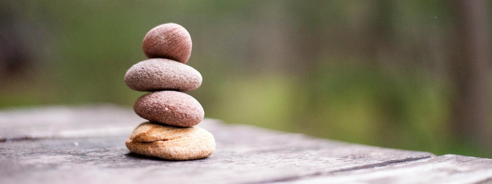 Steinturm auf einem Holztisch in der Natur