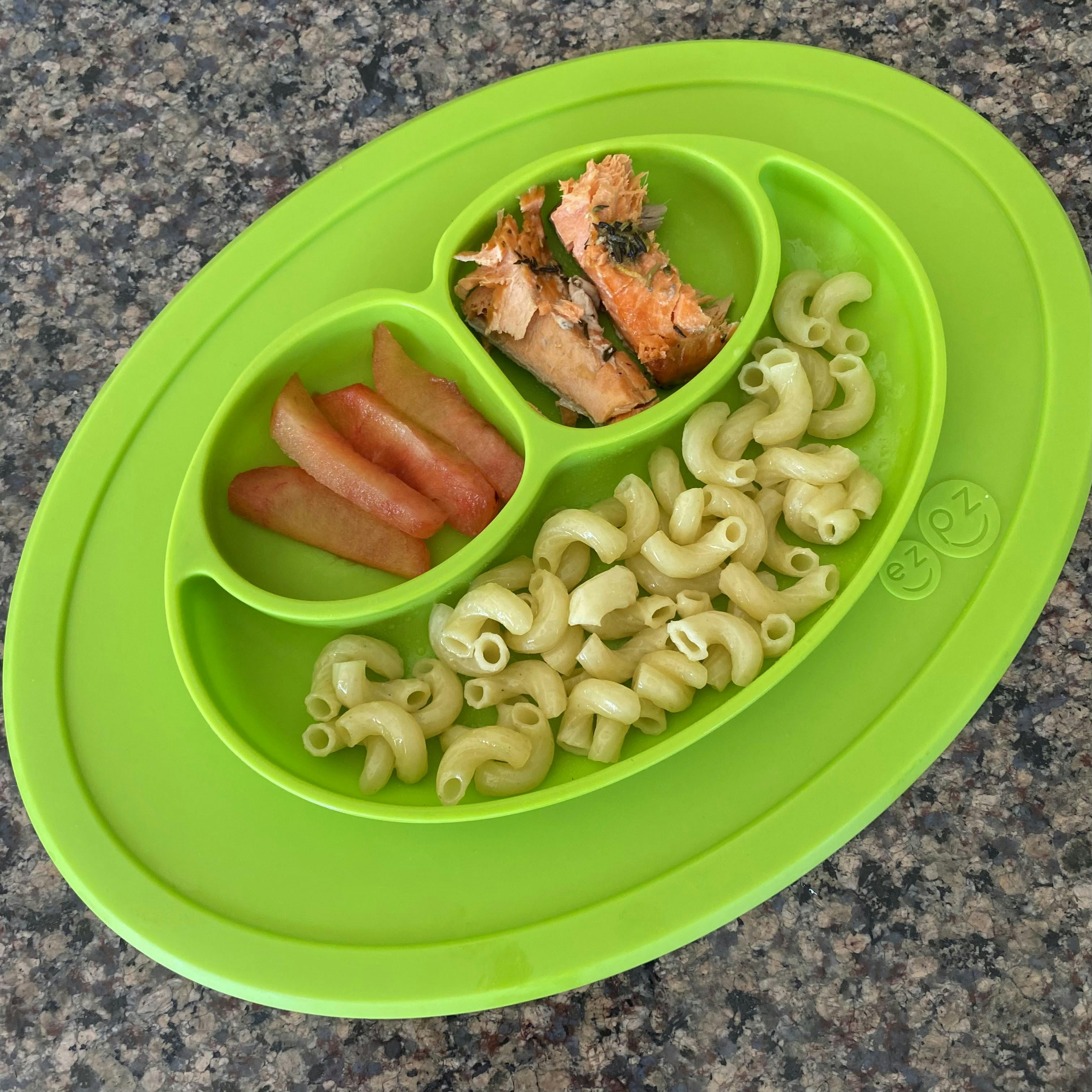 ezpz Mini Mat with plain pasta, strips of fruit and strips of salmon in the plate