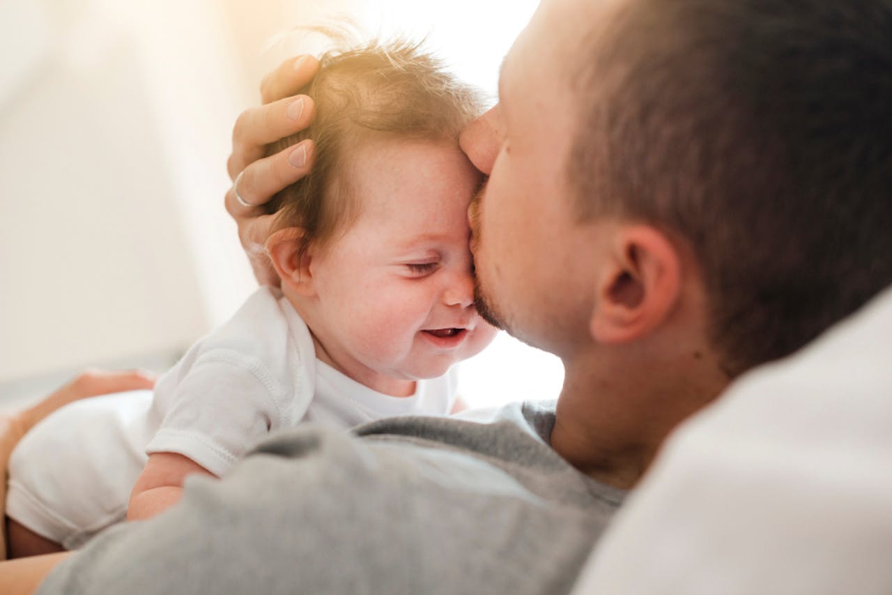 papa besando a bebe en la frente