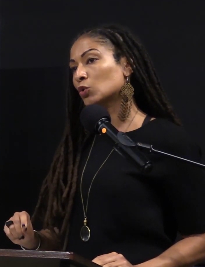 Princeton University professor Ruha Benjamin gives a presentation at a podium.