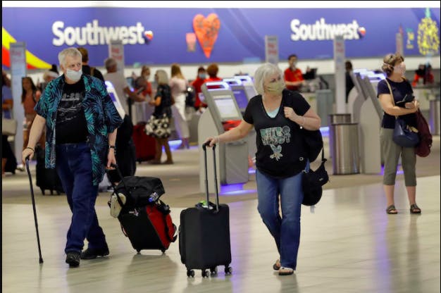 Passengers wearing protective face masks walk past the Southwest Airlines ticket counter on June 16 at Tampa International Airport. Southwest was among airlines that have signed letters of intent for government loans through the Cares Act.
