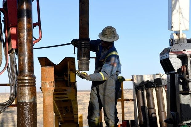 A worker drills for oil