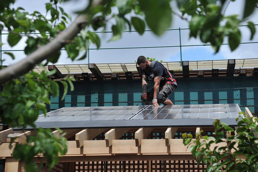 A worker installs solar panels in New York City