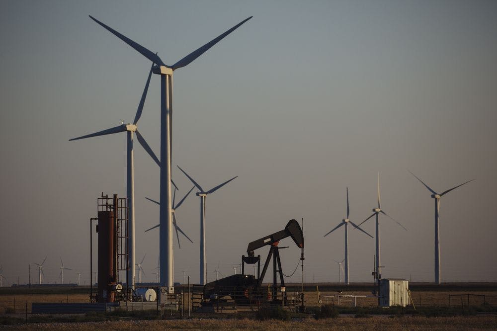 Wind turbines encircle a pump jack near Guymon, Oklahoma on Sept. 25, 2020.