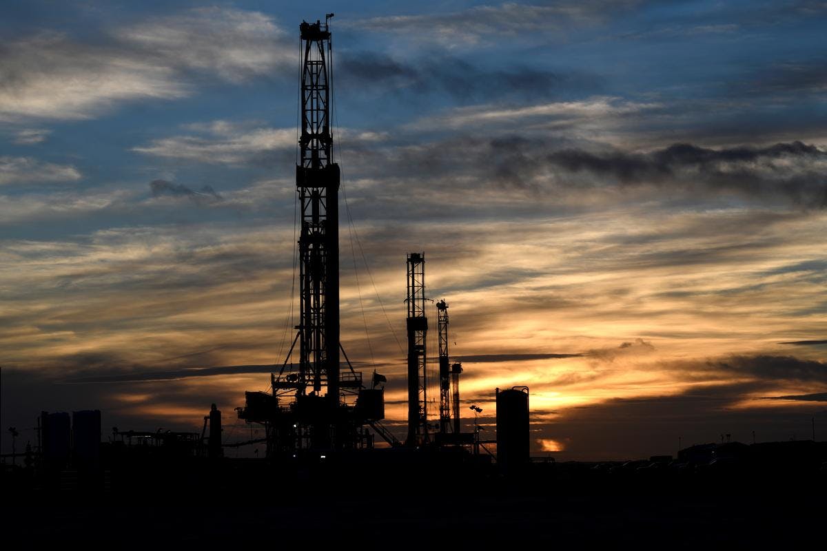 Drilling rigs operate at sunset in Midland, Texas U.S.