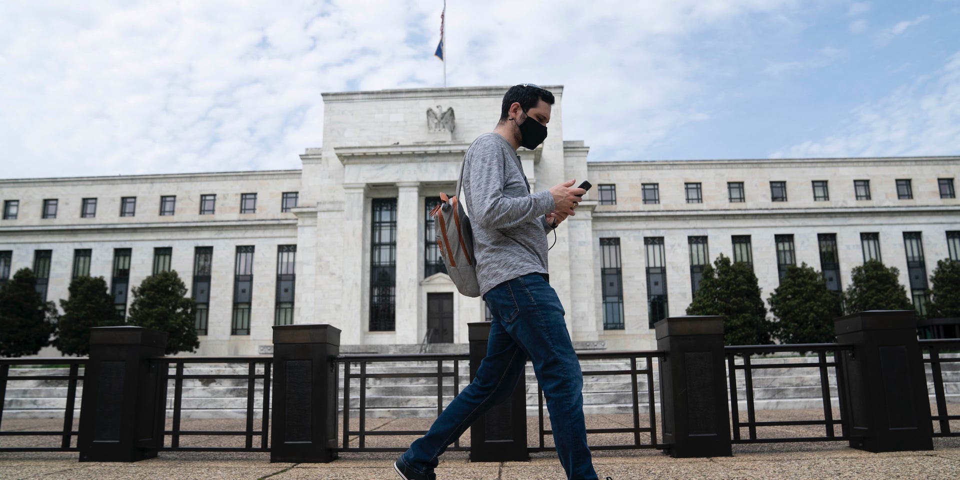 A pedestrian walks by the Federal Reserve building.