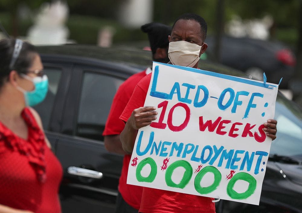 Protestor holds sign about unemployment