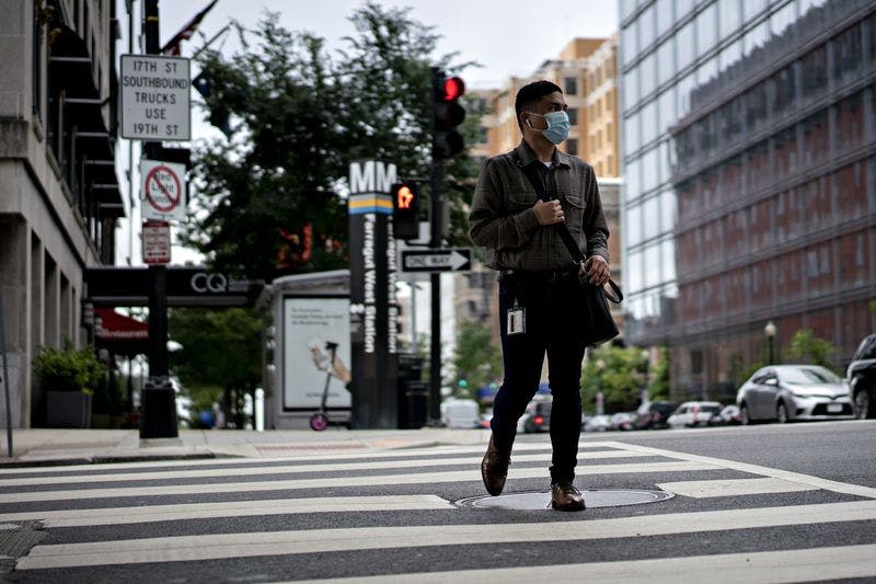 A pedestrian wears a protective mask while crossing the street in Washington, D.C., on May 29.
