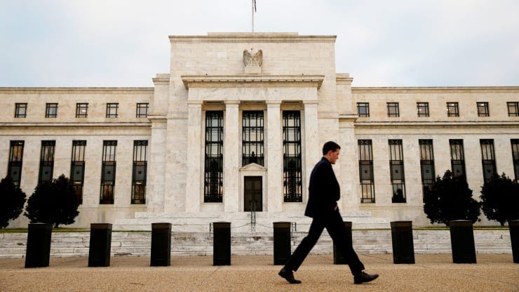 Man walks in front of the Federal Reserve building