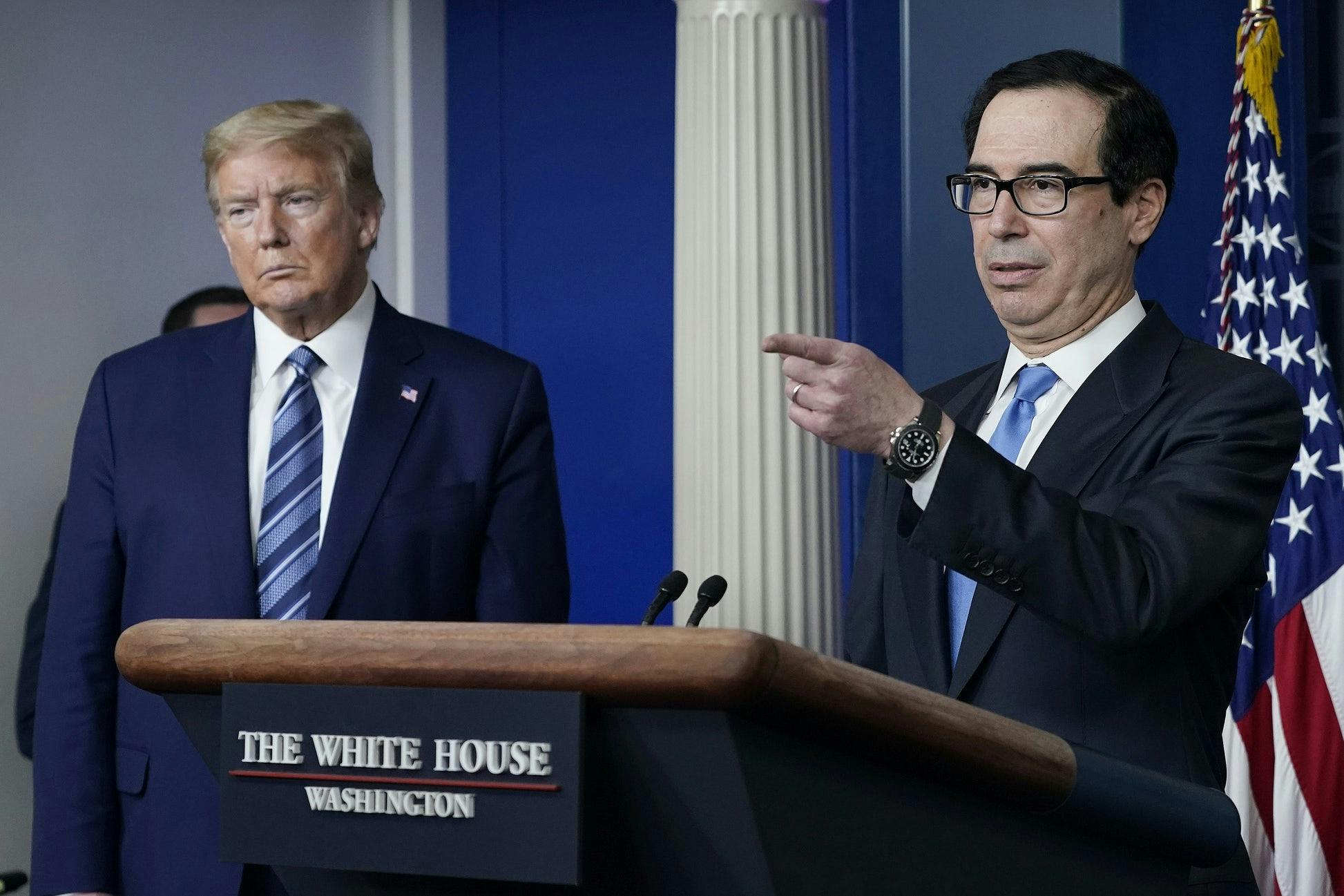 Treasury Secretary Steven Mnuchin speaks at the White House while President Donald Trump looks on