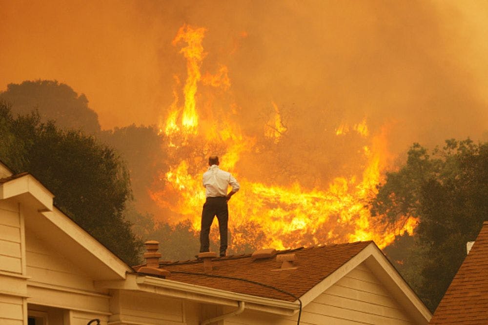 man roof burning house