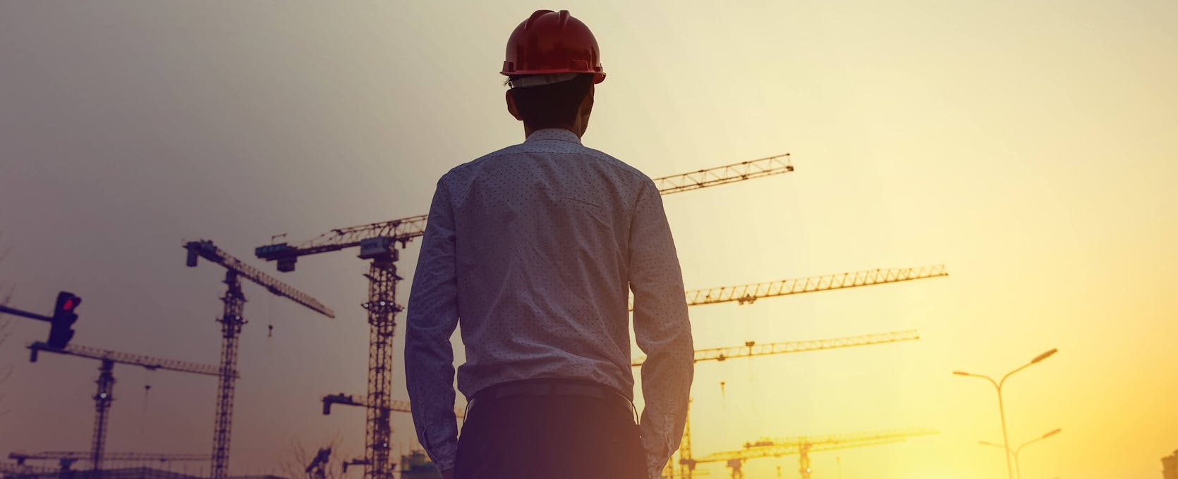 Contractor looks at construction site while considering project finance