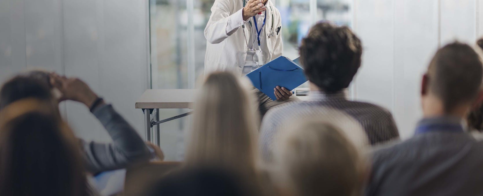 Doctor presenting information to a large crowd