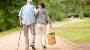 Senior patient walks with care giver