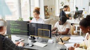 IT professionals working at table together in office on cybersecurity 