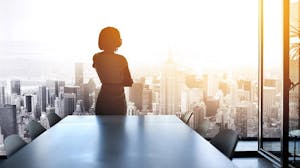 Woman overlooks the city from board room