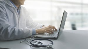 Doctor reviews patient data on computer