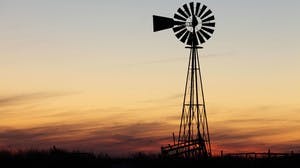 Windmill generating energy in the sunset