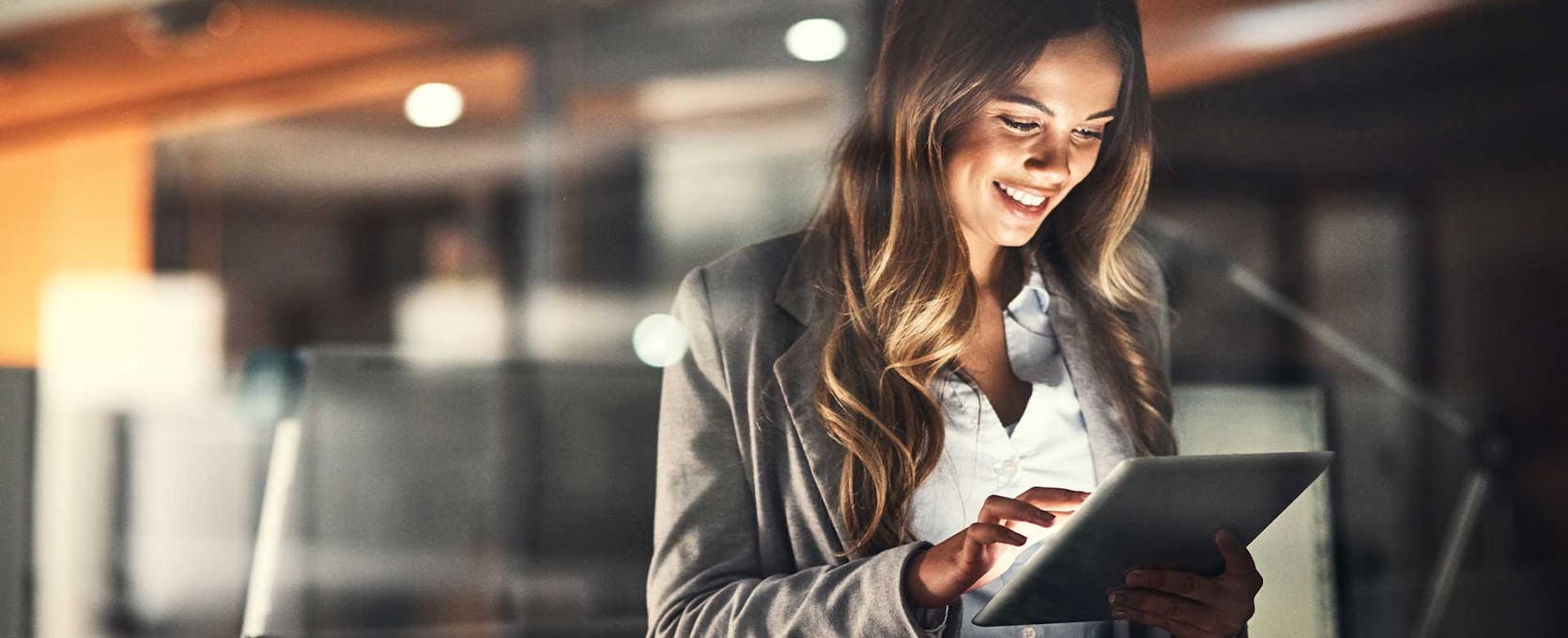 Woman accesses data analytics on a tablet in the office