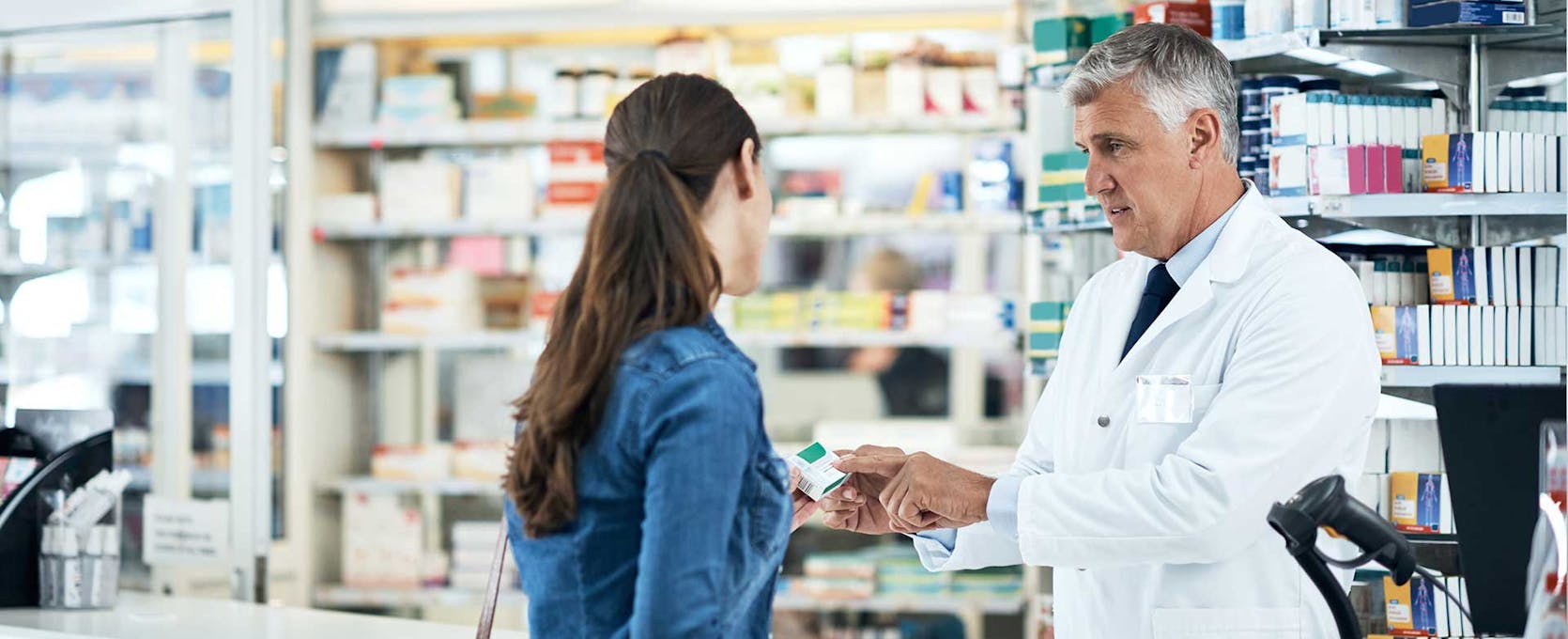 Pharmacist speaking with a customer at a pharmacy