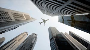 Airplane flies over buildings in a city