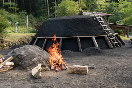 Im Freilichtmuseum Ballenberg wird gezeigt wie Holz zu Kohle verarbeitet wird.