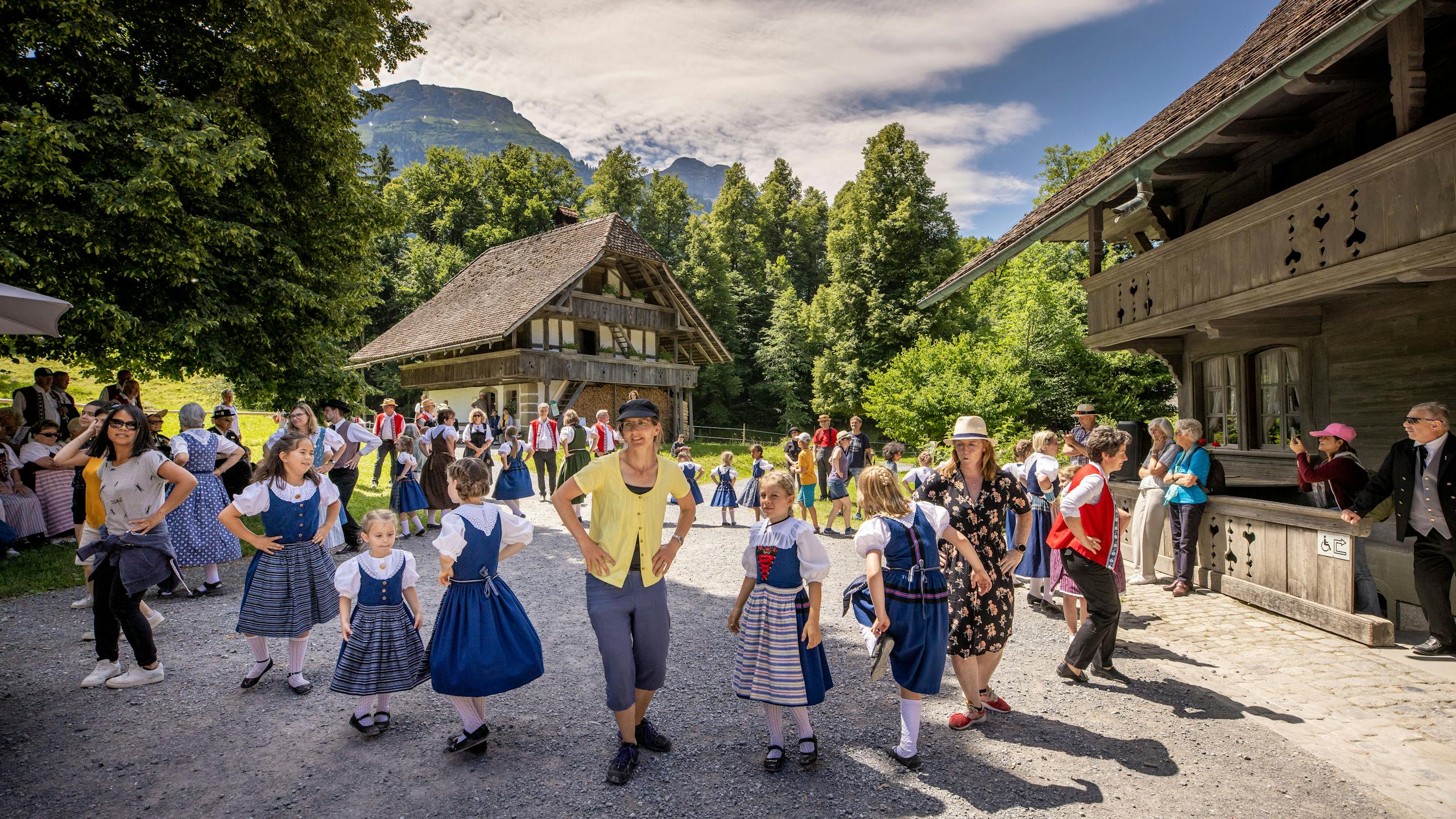 Trachten und Tänze: Besucherinnen und Besucher tanzen mit Kindern auf dem Ballenberg.